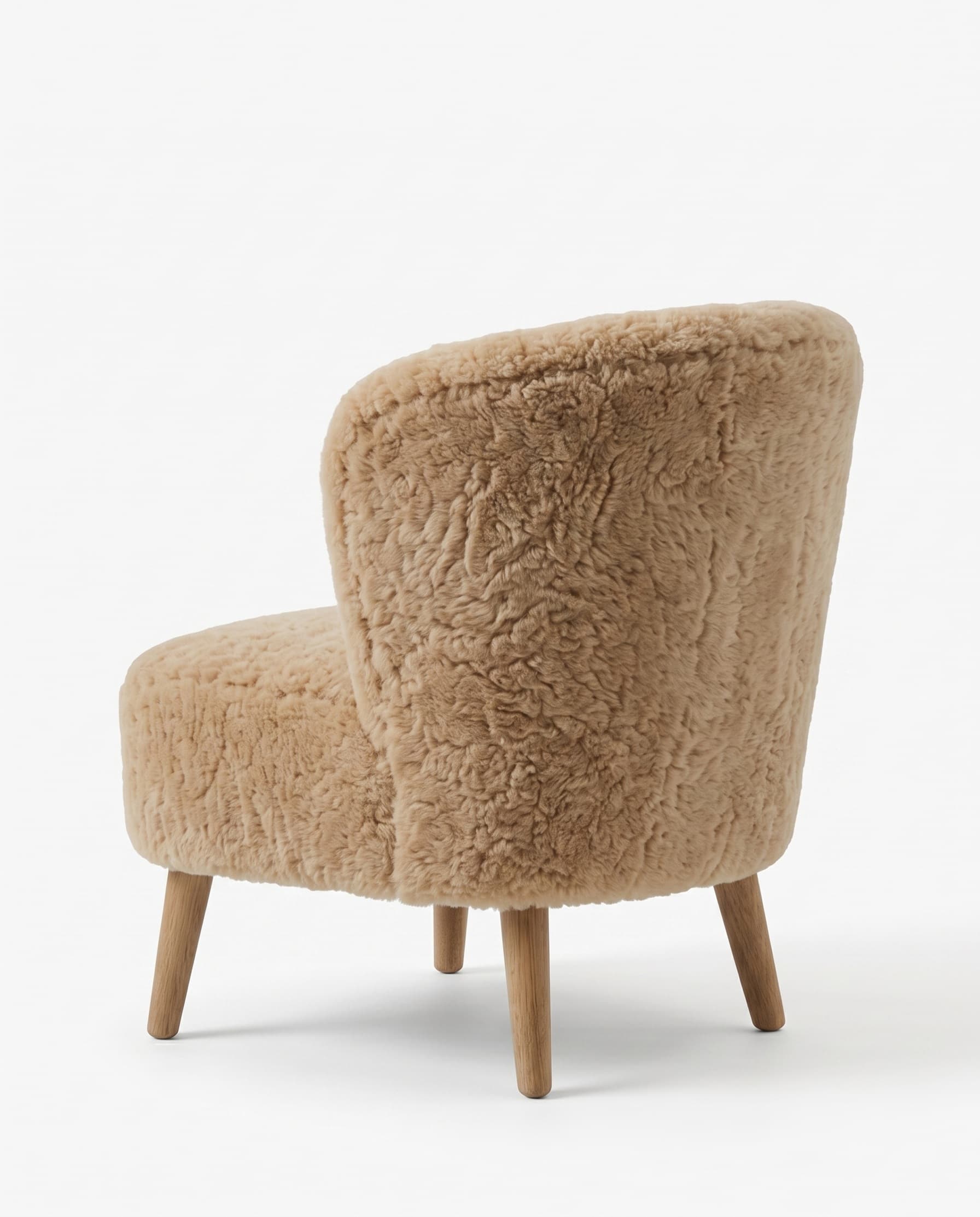 Fauteuil en peau lainée tondue vu de dos — dossier habillé sur toute sa courbe