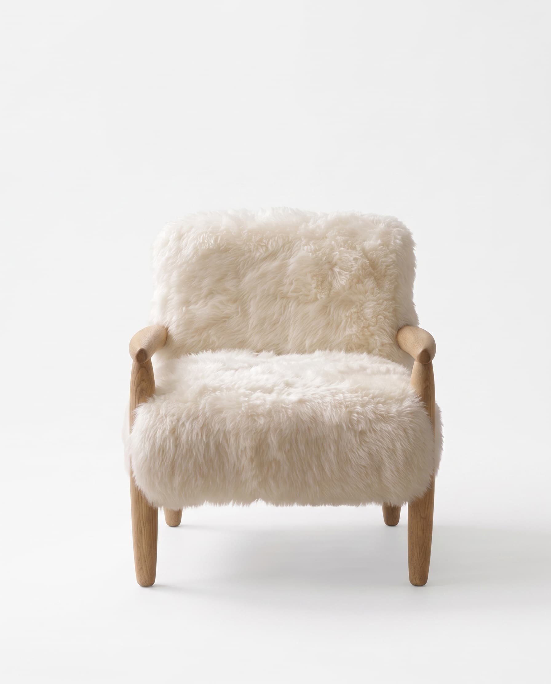 Fauteuil Arosa vu de face — accoudoirs et pieds en bois naturel apparents