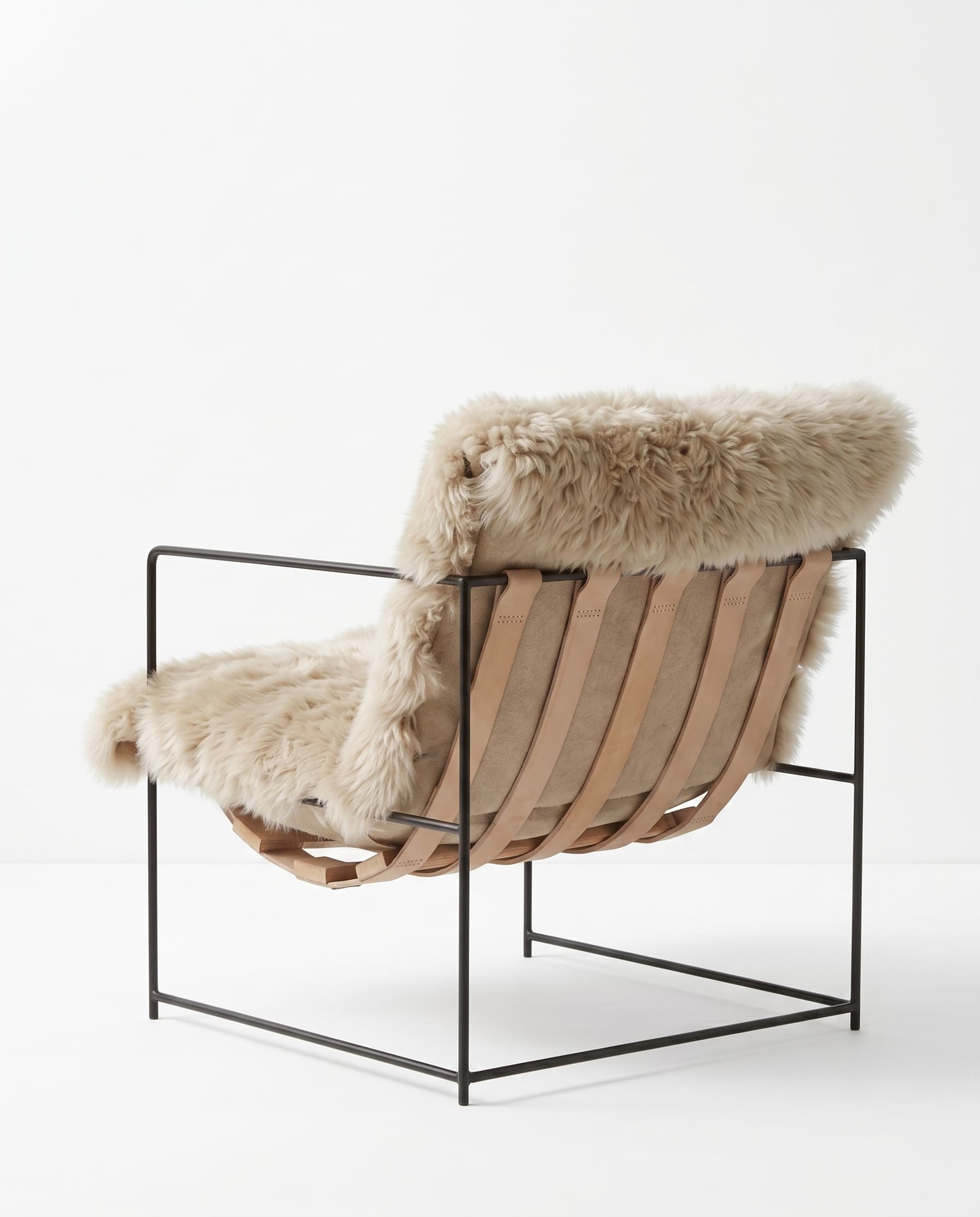 Fauteuil en peau de mouton de Nouvelle-Zélande vu de dos — sangles de cuir et cadre métal apparents