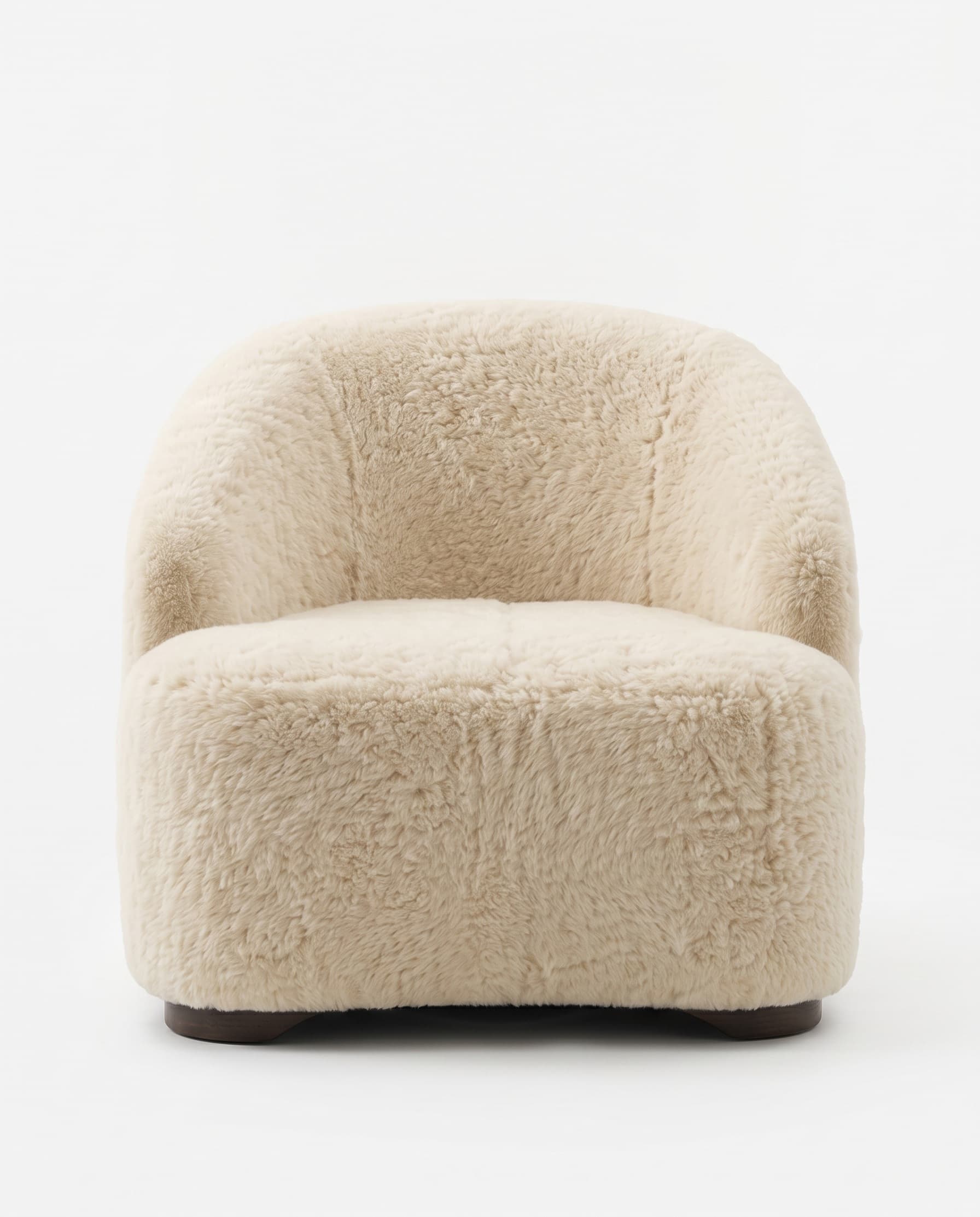 Fauteuil en peau lainée tondue vu de face — dossier enveloppant et socle en bois sombre