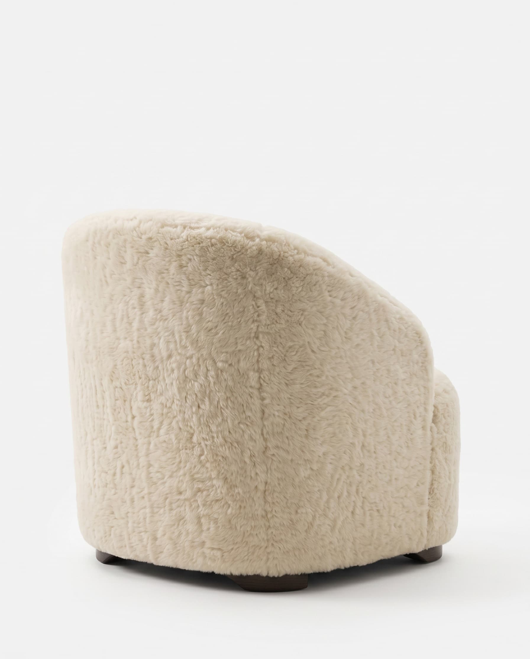 Fauteuil en peau lainée tondue vu de dos — coque entièrement habillée posée sur son socle