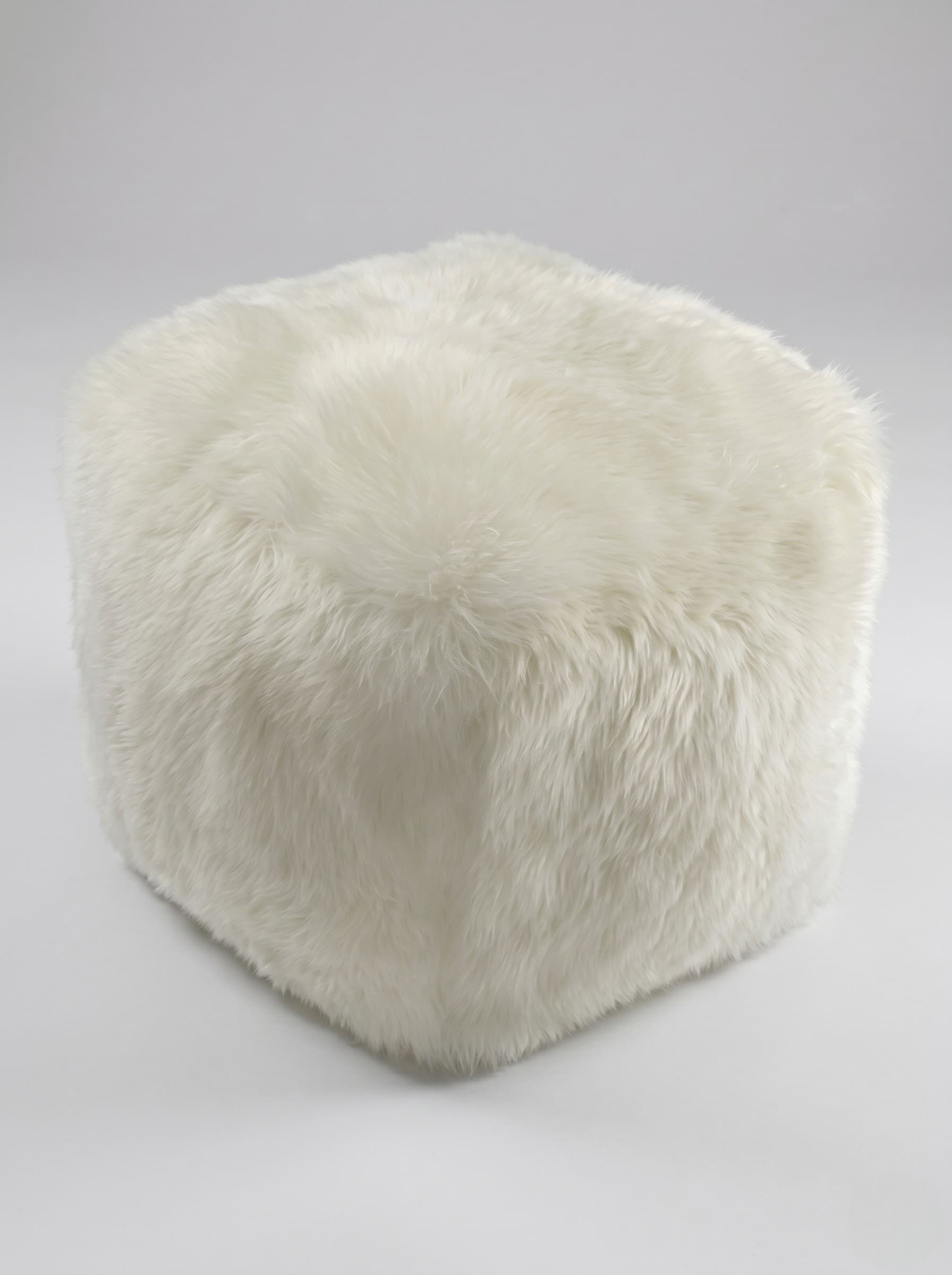 Pouf Vals cubique en peau lainée ivoire, vue de trois quarts