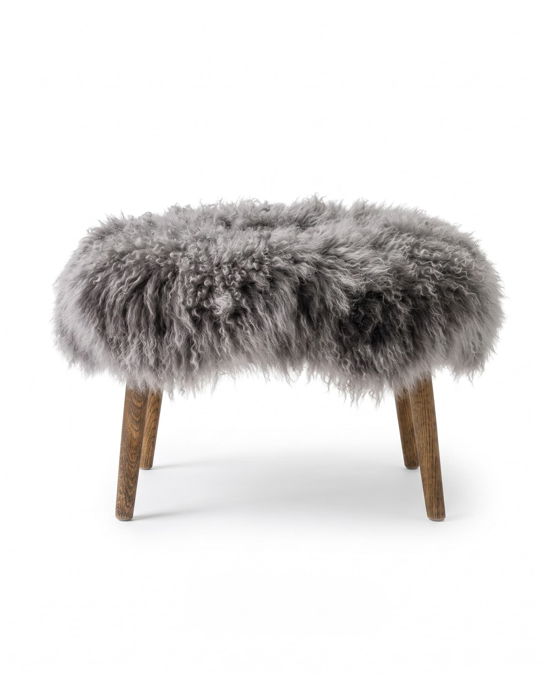 Tabouret en agneau tibétain vu de face — assise en longues mèches grises, quatre pieds fuselés en chêne